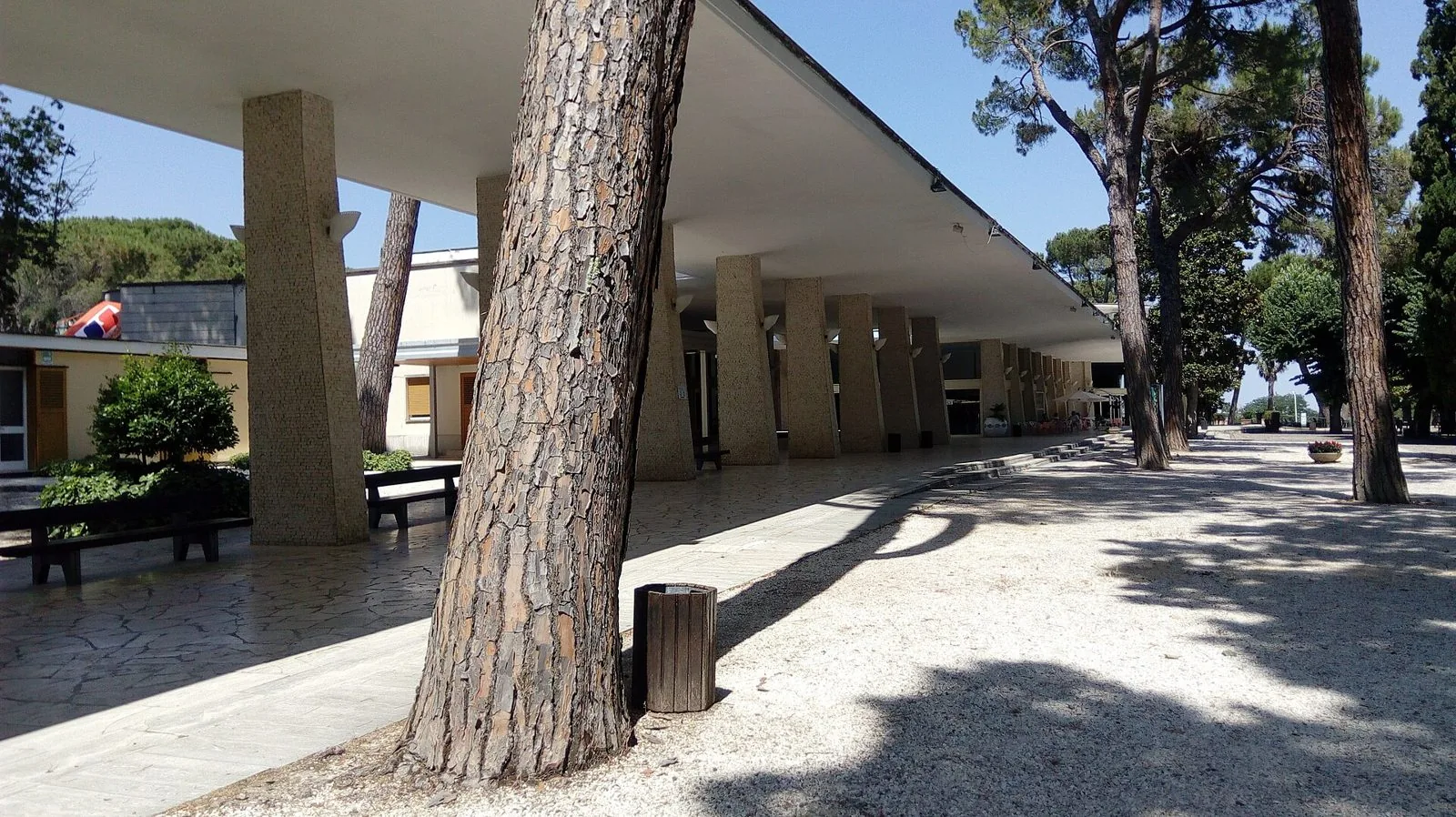 Il porticato e i pini del Parco Acqua Santa a Chianciano Terme in una giornata di sole
